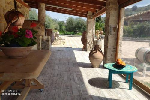 a patio with a table and vases on it at Stonehouse Olivelia - Afrathias Beach in Tympáki