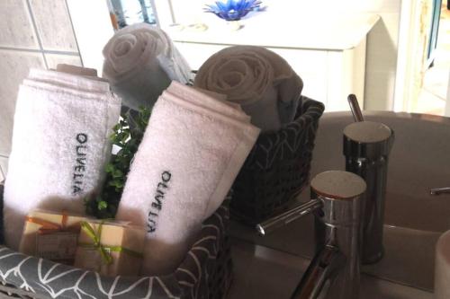 a basket filled with towels and a bottle of wine at Stonehouse Olivelia - Afrathias Beach in Tympáki