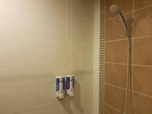 a bathroom with a shower with a shower head at Pangviman Place Resotel SHA Plus in Chiang Mai