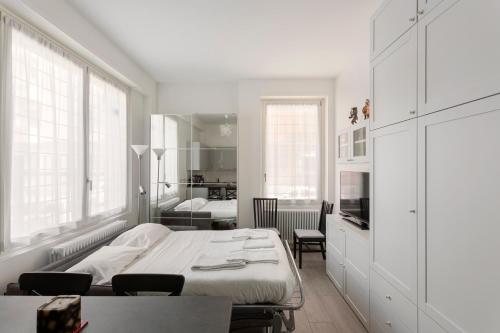 ein weißes Schlafzimmer mit einem Bett, einem Tisch und Stühlen in der Unterkunft The perfect one - Studio apt in Città Studi in Mailand