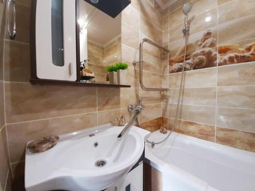 a bathroom with a tub and a sink and a toilet at Apartament on Krylova 19 in Bobruisk