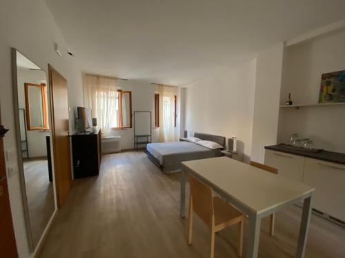 1 dormitorio con 1 cama y 1 mesa en una habitación en La Mansardina del Giardinetto, en Oderzo