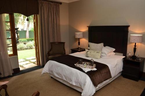 a bedroom with a large bed with a wooden headboard at College Lodge in Bloemfontein