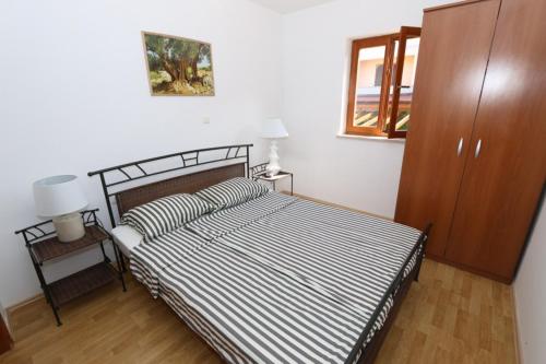 sypialnia z łóżkiem z czarno-białą kołdrą o paskach w obiekcie Apartment in Stara Novalja with sea view, balcony, air conditioning, WiFi (4897-1) w mieście Stara Novalja