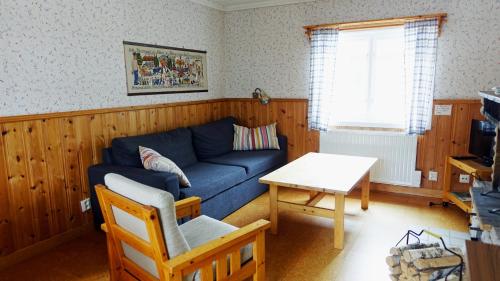 a living room with a blue couch and a table at Ekesberget Stugby Stuga 8 in Ekshärad