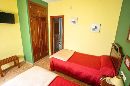a small room with a bed and a tv at Hotel Arunda II in Ronda