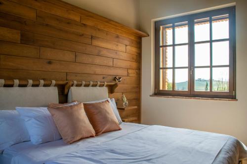 a bedroom with a bed with a wooden wall at Terra Antica - Resort, Winery & SPA in Montepulciano