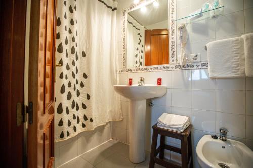 ein Badezimmer mit Waschbecken und Spiegel in der Unterkunft Hotel Arunda II in Ronda