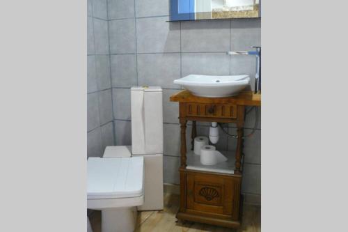 une salle de bain avec un lavabo blanc et des toilettes dans l'établissement Maisonnette de Mamie, à Pouilly-en-Auxois