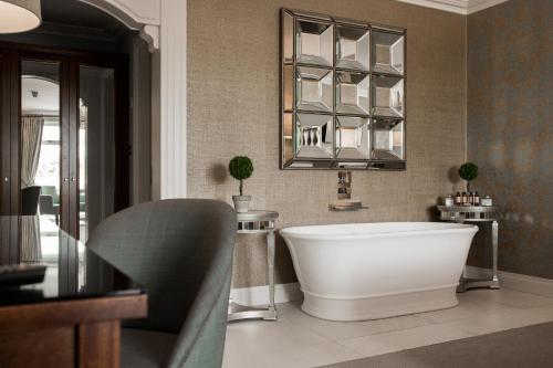 a bathroom with a large white tub and a mirror at Clanard Court Hotel in Athy