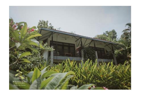 a house in the middle of a garden at Whispering Waters in Malayāttūr