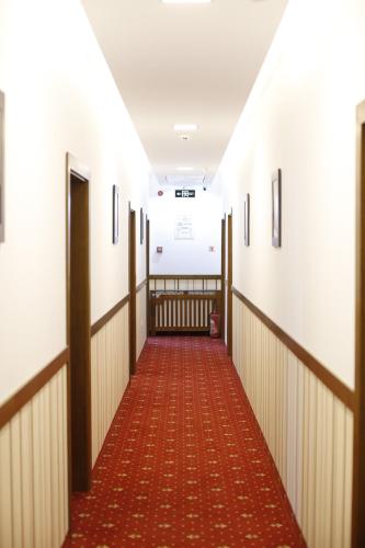 a corridor of a hospital with a red carpeted hallway at Hotel Bulevard in Făgăraş