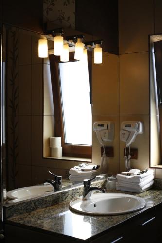 a bathroom with two sinks and a large mirror at Hotel Bulevard in Făgăraş