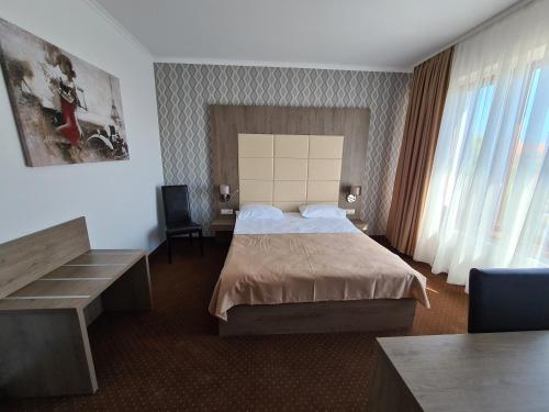 a hotel room with a bed and a desk at Hotel Bulevard in Făgăraş