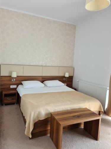 a bedroom with a large bed and two tables at Hotel Bulevard in Făgăraş
