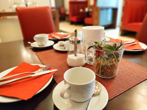 einen Tisch mit Tellern, Tassen und Küchenutensilien darauf in der Unterkunft Hotel Xtra Gleis in Hörstel