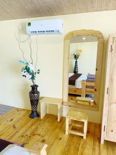 a bedroom with a mirror and a vase of flowers at Agonda Serenity Beach Villa in Agonda