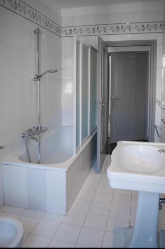 a white bathroom with a tub and a sink at Scrovegni Room & Breakfast in Padova