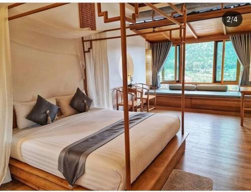 une chambre avec un lit à baldaquin dans une pièce dans l'établissement Lee Wine Ruk Thai Resort, à Ban Rak Thai