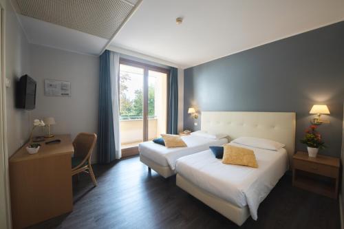 a hotel room with two beds and a window at Hotel Ristorante Primavera in Godega di SantʼUrbano