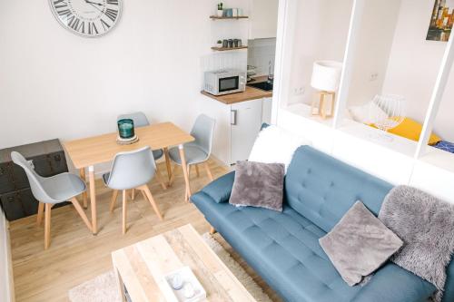 uma sala de estar com um sofá azul e uma mesa em AuPetitSaumur - LPC em Saumur