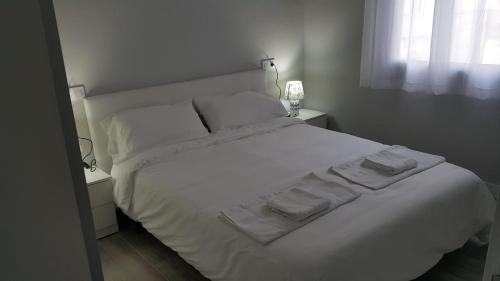 a white bed with two towels on top of it at GS ALCÁZAR in Talavera de la Reina