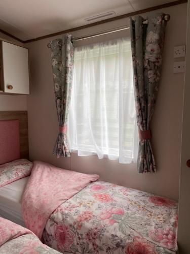 a bedroom with a bed and a window with curtains at The Wimbledon in Dunoon