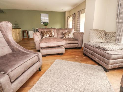 a living room with a couch and a chair and a couch at 9 Riverside Walk in Skipton