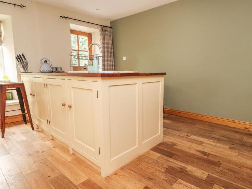 a kitchen with white cabinets and a sink at 9 Riverside Walk in Skipton