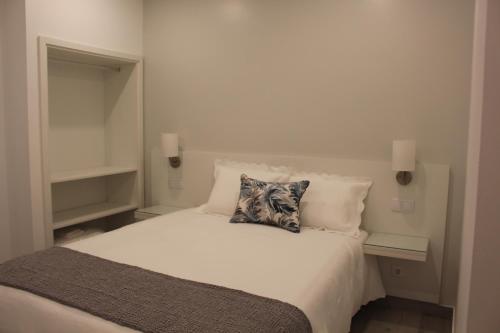 um quarto com uma cama branca e 2 almofadas em Hotel Beatriz em Serpa