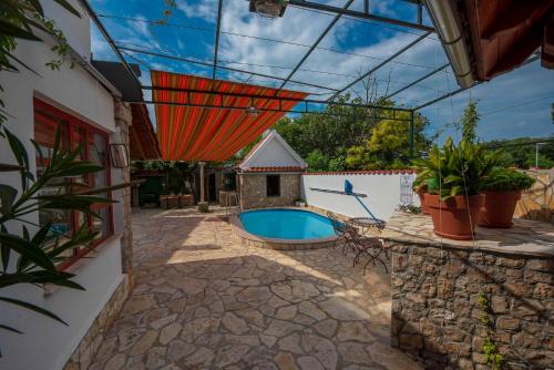 un patio con piscina e una casa di Stone house Morlako - with pool a Velika Čista