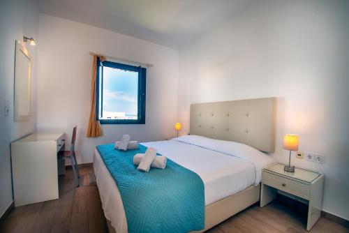a bedroom with a bed with two towels on it at Palatia Village Hotel Apartments in Hersonissos
