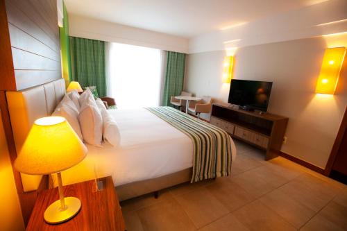 a hotel room with a bed and a television at Vidam Hotel Aracaju - Transamerica Collection in Aracaju