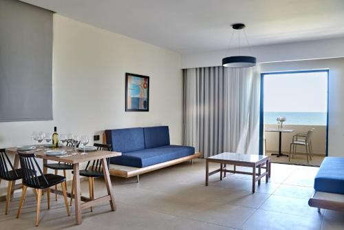 a living room with a blue couch and a table at Silver Beach Hotel & Apartments in Gerani Chanion