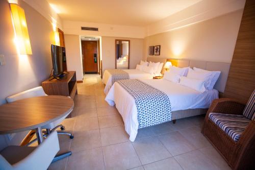 a hotel room with two beds and a flat screen tv at Vidam Hotel Aracaju - Transamerica Collection in Aracaju