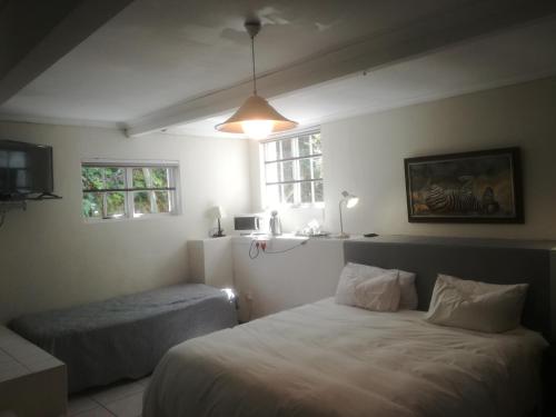1 dormitorio con 2 camas y ventana en Valley Guest House en Puerto Elizabeth