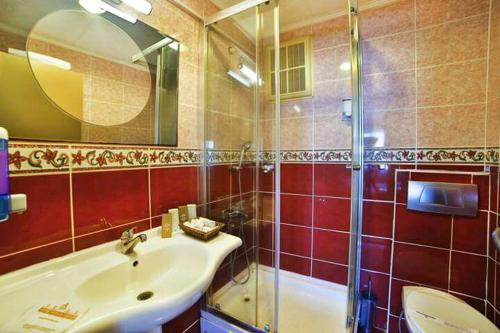 y baño con lavabo y ducha. en Laleli Emin Hotel, en Estambul