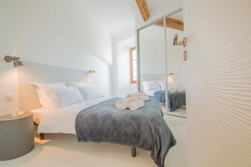 Habitación blanca con cama y espejo en Sunlight Properties - BO - Hyper central, balcony, 5 mins to the beach, en Niza