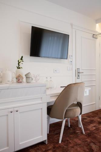 a white desk with a chair and a tv on the wall at Mały Sopot Boutique in Iława