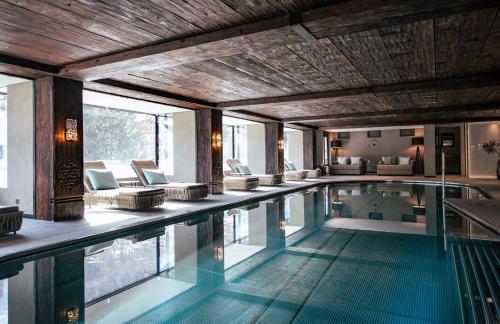 an indoor swimming pool with a wooden ceiling at Wellness Hotel Alpenhof in Zermatt
