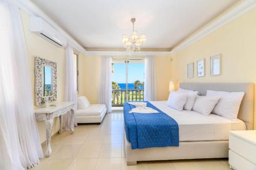 Schlafzimmer mit einem Bett und Meerblick in der Unterkunft Royal Beachfront Villa in Protaras
