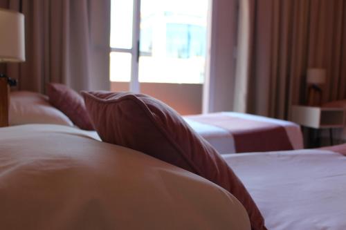 a hotel room with two beds and a window at HOTEL CITY in Posadas
