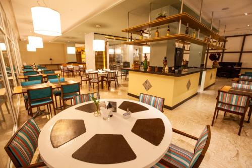a restaurant with a large white table and chairs at Vidam Hotel Aracaju - Transamerica Collection in Aracaju