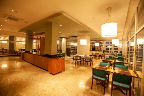 a restaurant with tables and chairs in a room at Vidam Hotel Aracaju - Transamerica Collection in Aracaju