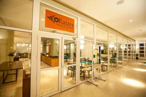 a restaurant with tables and chairs in a building at Vidam Hotel Aracaju - Transamerica Collection in Aracaju