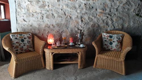 two wicker chairs and a table with candles on it at La Mora Exclusive in Moricone