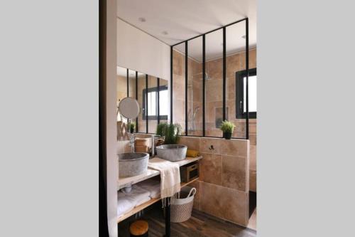a bathroom with two sinks and a large mirror at Le Galinié Chic'Art. Un bel Atelier avec Piscine in Carpentras