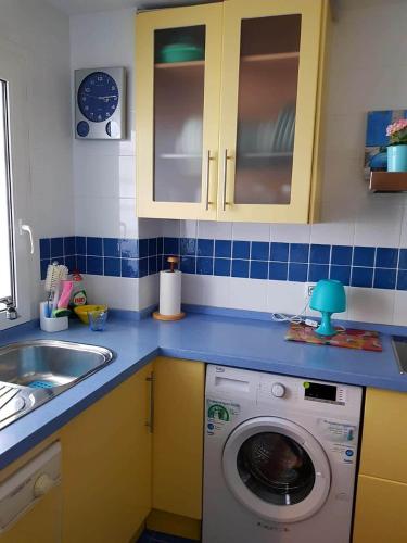 a kitchen with a washing machine and a sink at APARTAMENTO CORTADURA BEACH in Cádiz