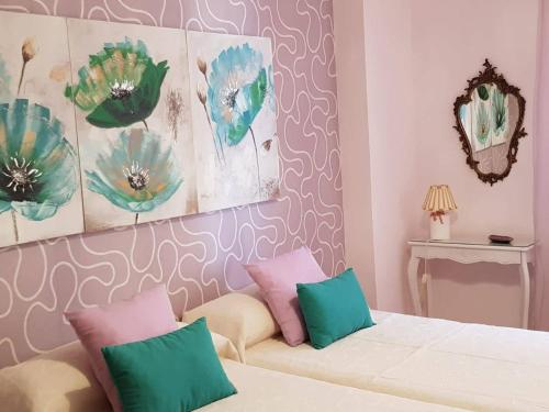 a bedroom with a bed and a couch with pillows at APARTAMENTO CORTADURA BEACH in Cádiz