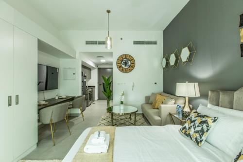 a room with a bed and a living room at Primestay - Chic & Gorgeous studio in Al Barsha in Dubai